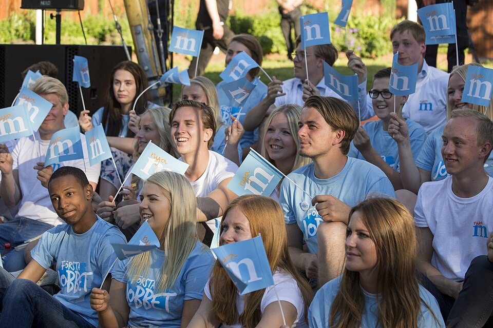 Young Moderates supporters wave party flags in Stockholm. Credit: Per Pettersson.